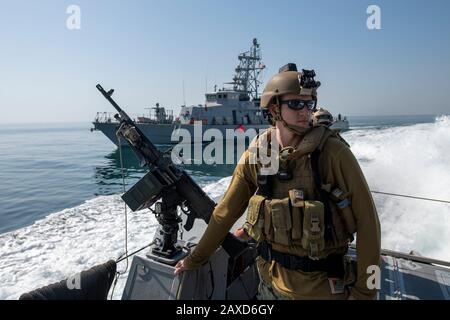 U.S. Navy Electronics Technician 1st Class Michael Drigger, assegnato a Coastal Riverine Squadron Four, Alpha Company, Boat Team One, mans, una mitragliatrice M240B a bordo di una nave Mark VI Patrol durante un esercizio 31 gennaio 2019 nel Golfo Arabico. Foto Stock