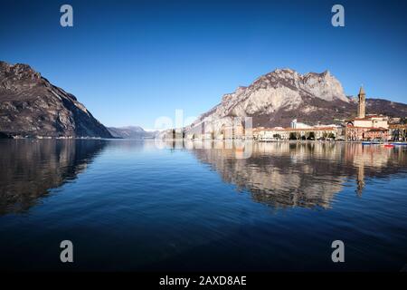 Splendida vista panoramica di Lecco riflessa sul lago di Como con le montagne alle spalle, Italia Foto Stock