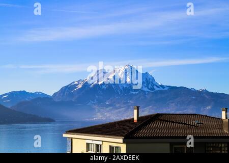 Panorama panaramico sul cielo blu, del Monte Pilatus che torreggia in modo imponente sul Vierwaldstattersee, sul Lago Luchern, Svizzera Foto Stock