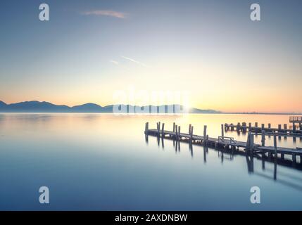 Due pontili in legno o banchine e il lago di sunrise. Torre del Lago Puccini, Versilia, il lago di Massaciuccoli, Toscana, Italia, Europa Foto Stock