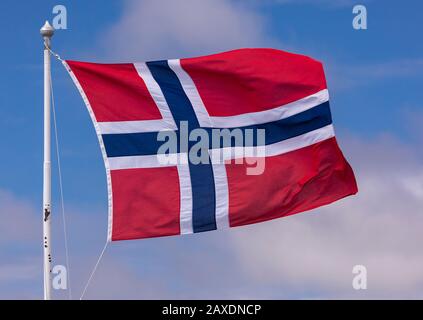 Bergen, NORVEGIA - Bandiera della Norvegia che vola su flagpole. Foto Stock