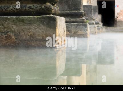 Il vapore che sale galleggia attraverso l'acqua di sorgente del Grande bagno nelle storiche Terme Romane, Città di Bath, Somerset, Regno Unito Foto Stock
