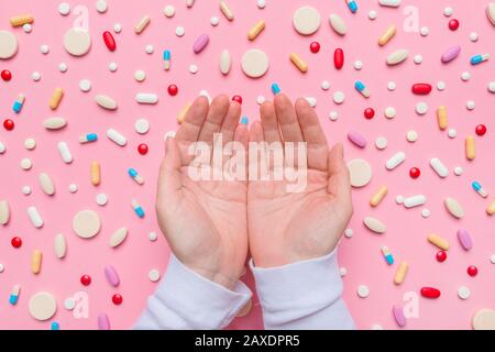 Concetto di controllo delle nascite con le mani cucite sopra le pillole, vista dall'alto a disposizione piatta Foto Stock