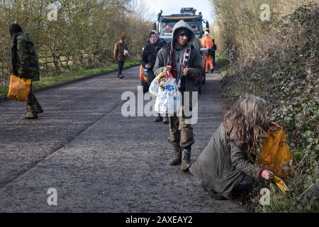 Denham, Regno Unito. 11 Febbraio 2020. Attivisti ambientali da Extinction Rebellion, Stop HS2 e Save the Colne Valley pick up lettiera come loro ‘slow walk’ di fronte a un grande camion che trasporta un carrello elevatore JCB a un sito HS2 a Denham nella Valle Colne. Gli appaltatori che lavorano per conto di HS2 stanno reinstradando i tralicci dell'elettricità attraverso un luogo Di Importanza metropolitana per la conservazione della natura (SMI) insieme al collegamento ferroviario ad alta velocità. Credit: Mark Kerrison/Alamy Live News Foto Stock