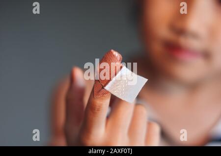 La ragazza prima ferita del dito di aiuto da se stessa Foto Stock