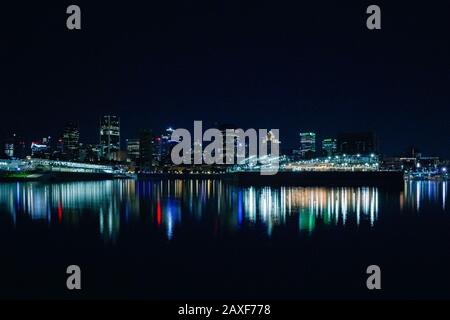 Splendido skyline notturno del porto di Dieppe Park con riflessi di luce colorati sul fiume Foto Stock