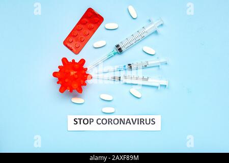 Medicinali contro il modello Coronavirus. Pillole diverse, siringhe, testo STOP CORONAVIRUS. 2019 nCoV coronavirus su sfondo blu. Wuhan virus, cinese Foto Stock