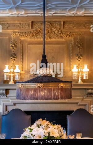 Lampadario sopra tavolo da pranzo in un palazzo storico Foto Stock