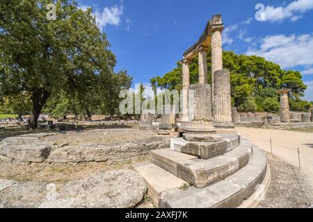 Turisti visitano le antiche Philippeion nell'Altis di Olympia, un tensioattivo ionico memorial circolari in pietra e marmo in Olympia, Grecia. Foto Stock