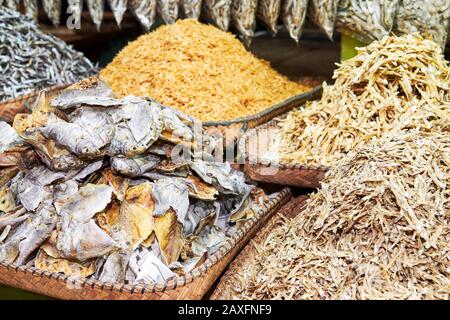 Primo piano di mucchi di piccoli pesci secchi e salati in cestini di bambù al mercato Centrale Bagnato a Iloilo, una prelibatezza locale nelle Filippine, Asia Foto Stock