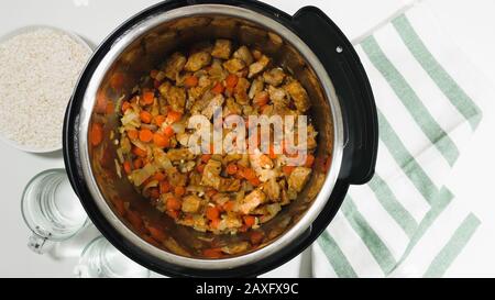 Cottura del riso con carne e verdure in pressione multi-cucina passo dopo passo, vista dall'alto. Saltate carne e verdure marinate tritate. Foto Stock