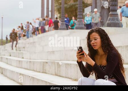 Attraente donna che texting sullo smartphone sulle scale. Spazio vuoto per il testo Foto Stock