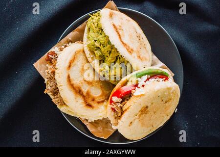 Arepa venezuelana su una vista piatta, sfondo nero Foto Stock