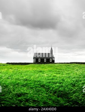 Splendido paesaggio con la famosa e pittoresca chiesa nera di Budir nella regione della penisola di Snaefellsnes in Islanda e campo di bellezza verde erba Foto Stock
