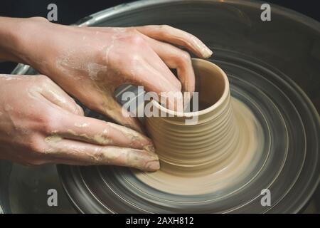 Creazione di un vaso di argilla bianca di close-up. Lo scultore in officina rende una brocca di coccio closeup. Twisted tornio del vasaio. Master coccio. Foto Stock