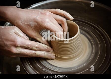 Creazione di un vaso di argilla bianca di close-up. Lo scultore in officina rende una brocca di coccio closeup. Twisted tornio del vasaio. Master coccio. Foto Stock