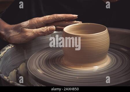 Master class sulla modellazione di argilla su un tornio del vasaio nel laboratorio di ceramica Foto Stock