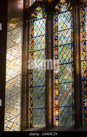 La chiesa di Sant'Andrea ha riflessi di vetro colorato a Castle Combe, Inghilterra, Cotswolds. Foto Stock