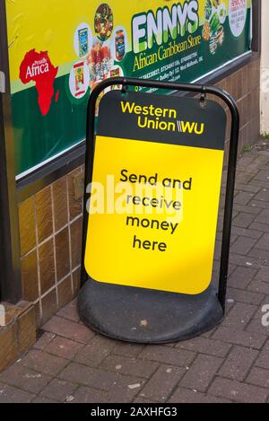 Firma all'esterno del negozio che fa pubblicità ai servizi di trasferimento di denaro di Western Union Foto Stock