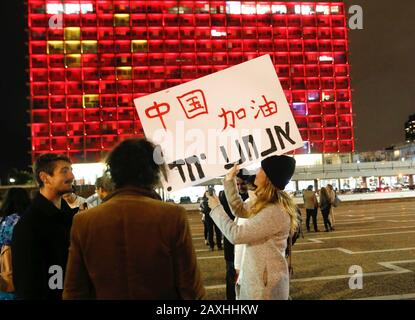 Tel Aviv, Israele. 11th Feb, 2020. Una donna tiene un placard per rallegrarsi per la Cina di fronte al Municipio di Tel Aviv a Tel Aviv, Israele, 11 febbraio 2020. La Hall del comune di Tel Aviv è illuminata dai colori della bandiera nazionale cinese in solidarietà con la lotta della Cina contro la nuova epidemia di coronavirus. Credit: Gil Cohen Magen/Xinhua/Alamy Live News Foto Stock