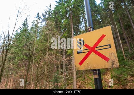 Rathen, Germania. 11th Feb, 2020. Nella fase rocciosa nella località di salute Rathen, un cartello di divieto con il significato di 'fuoco' è attaccato a un palo luminoso sul lato strada. In molti luoghi del Parco Nazionale della Svizzera sassone, gli incendi aperti sono generalmente vietati e puniti con severe sanzioni. Credito: Daniel Schäfer/Dpa-Zentralbild/Dpa/Alamy Live News Foto Stock