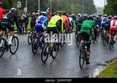 Uomini di corsa in bicicletta (ciclisti in bicicletta in peloton) equitazione & competere in gara guardato da tifosi in pioggia - UCI World Championships, Yorkshire, UK Foto Stock