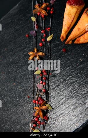 Pate di coniglio in corni croccanti decorato con spezie su un piatto di pietra nera Foto Stock