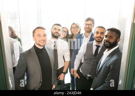 Gruppo multietnico di specialisti di business in eleganti abiti formali in piedi in entrata e guardare la macchina fotografica Foto Stock
