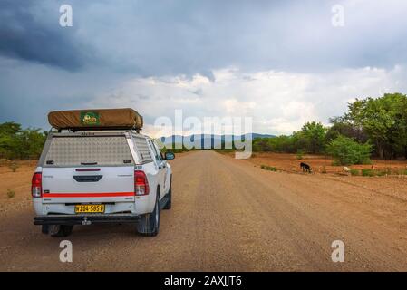 Auto suv 4x4 dotata di tenda da tetto che attraversa la regione di Kunene in Namibia Foto Stock