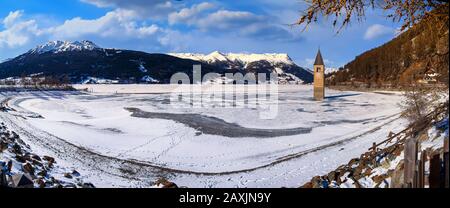 Paesaggio invernale nelle Alpi con la famosa torre della chiesa sommersa a Reschensee al confine tra l'Alto Adige e l'Austria Foto Stock