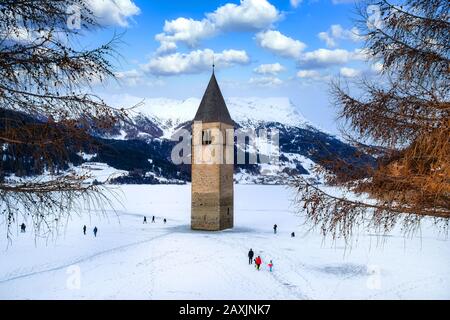 Paesaggio invernale nelle Alpi con la famosa torre della chiesa sommersa a Reschensee al confine tra l'Alto Adige e l'Austria Foto Stock