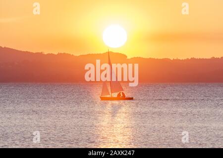 Barca a vela sul lago Chiemsee, Chiemgau Alpi dietro, Übersee, Chiemgau, alta Baviera, Baviera, Germania meridionale, Germania, Europa Foto Stock