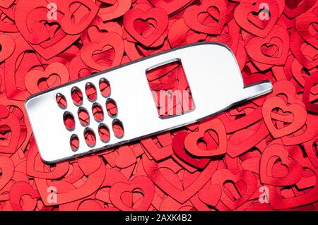 Luminoso cellulare grafico seduto su un letto di romantico cuore rosso pronto per il messaggio di San Valentino Foto Stock
