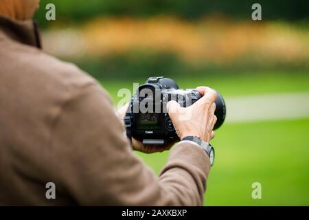Uomo di mezza età che usa una fotocamera professionale Foto Stock