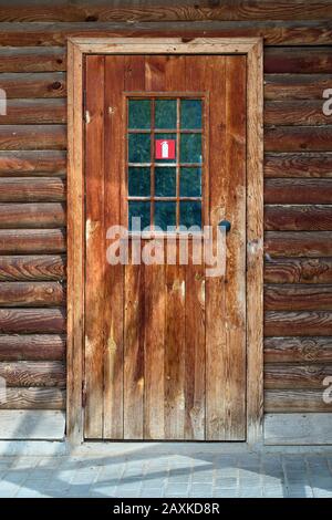 Targhetta con il logo dell'estintore rosso sulla porta di una vecchia casa in legno come misura di sicurezza e prevenzione degli incendi negli edifici residenziali. Concetto di assicurazione an Foto Stock