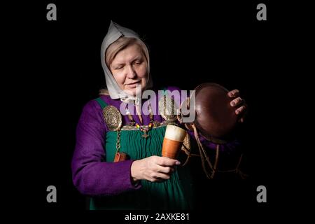 Studio ritratto di una donna bionda matura in costume vichingo, con un pallone e un corno per bere. Ritratto di un amante della storia vivente Foto Stock