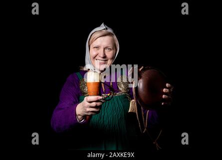 Studio ritratto di una donna bionda matura in costume vichingo, con un pallone e un corno per bere. Ritratto di un amante della storia vivente Foto Stock