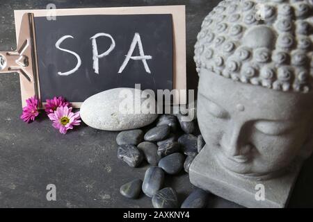 testa di buddha con pietre, fiori e tabulare Foto Stock