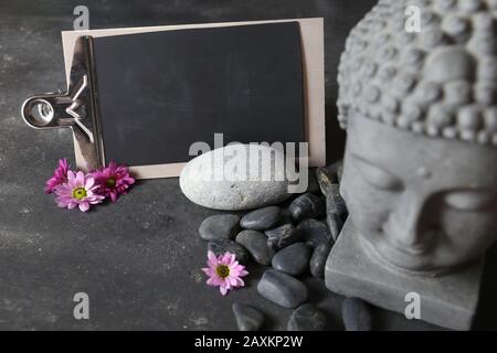 testa di buddha con pietre, fiori e tabulare Foto Stock