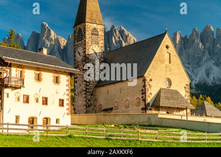 Chiesa di Santa Maddalena incorniciata dalle maestose vette delle Odle al tramonto, Val di Funes, Dolomiti, Alto Adige, Italia Foto Stock