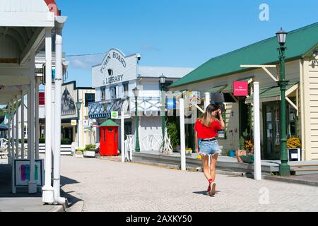 Tauranga Nuova Zelanda - 24 gennaio 2019; strada di edifici storici con visitatore in cima rosso brillante a piedi nel villaggio storico di Tauranga. Foto Stock