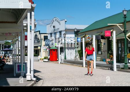 Tauranga Nuova Zelanda - 24 gennaio 2019; strada di edifici storici con visitatore in cima rosso brillante a piedi nel villaggio storico di Tauranga. Foto Stock