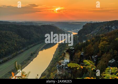 Vista dal ponte di Bastei sulla valle dell'Elba nel Parco Nazionale della Svizzera Sassonia. Fiume Elba al tramonto. Paesaggio con rocce, alberi e foreste Foto Stock