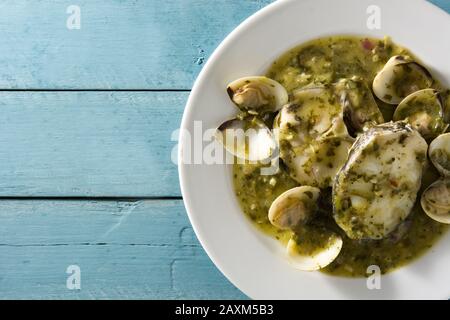 Pesce nasello e vongole con salsa verde su fondo verde Foto Stock