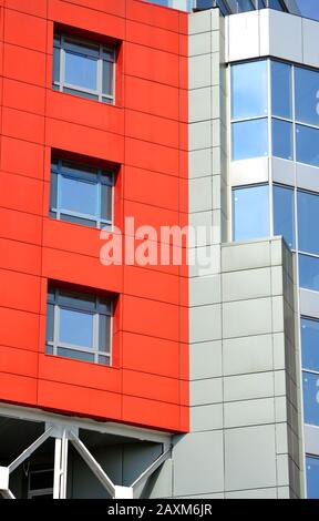facciata astratta di un edificio moderno. Colore rosso, grigio, blu. Finestre quadrate Foto Stock