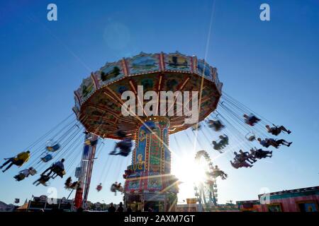 Germania, Baviera, Monaco, 'Oktoberfest', chairoplane in controluce, motion blur Foto Stock