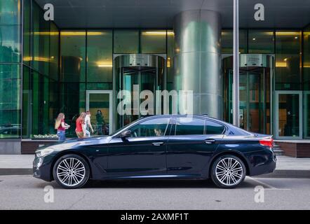 Russia Mosca 2019-06-17 Moderna auto d'affari di prestigio classe auto BMW 535i berlina parcheggiata sulla strada vicino all'ingresso alla costruzione di Mosca città business Foto Stock