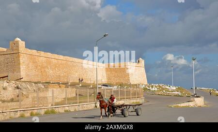 Mahdia, TUNISIA - 28 DICEMBRE 2019: Una carrozza trainata da un cavallo di fronte alla fortezza ottomana Borj el Kebir Foto Stock