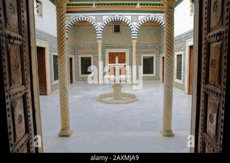 Tunisi, TUNISIA - 08 DICEMBRE 2019: Piccolo patio con fontana in marmo all'interno del Museo del Bardo, con ceramiche, colonne e portici Foto Stock