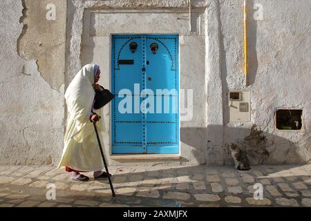 Tunisi, TUNISIA - 09 DICEMBRE 2019: Tipica strada acciottolata e stretta (via Pacha) all'interno della storica medina di Tunisi, con una porta colorata e un Foto Stock